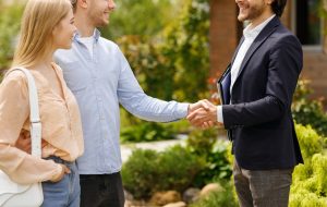 cropped view of real estate broker shaking hands with his clients closing house rental deal