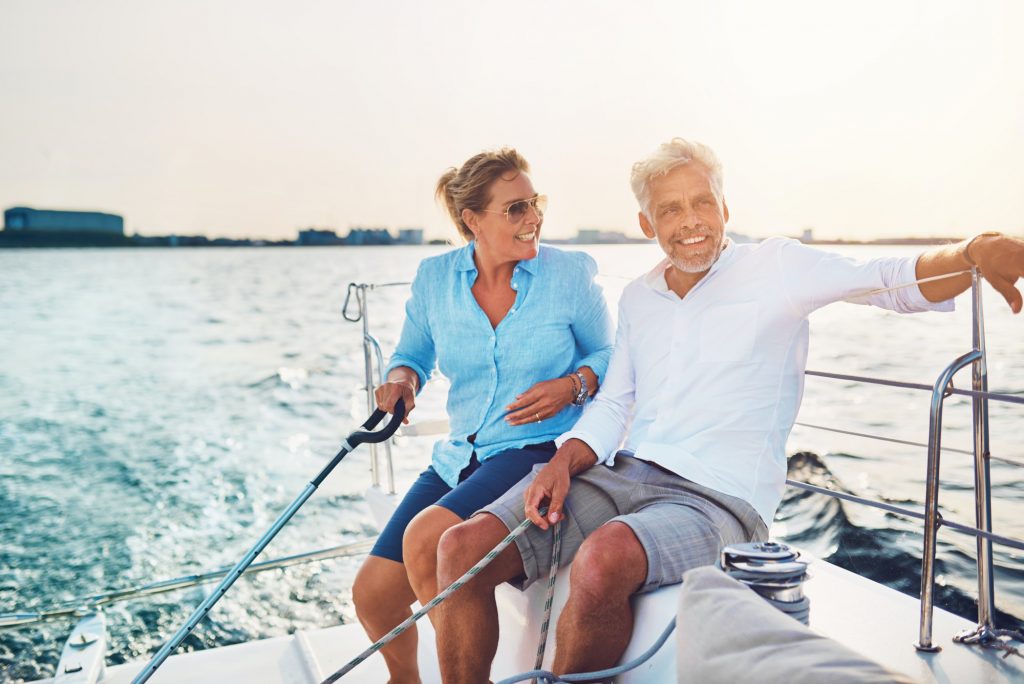 smiling mature couple enjoying a sunny day sailing together