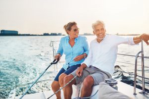 smiling mature couple enjoying a sunny day sailing together