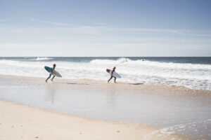 children surfing nazare portugal children teenagers wetsuits surf boards