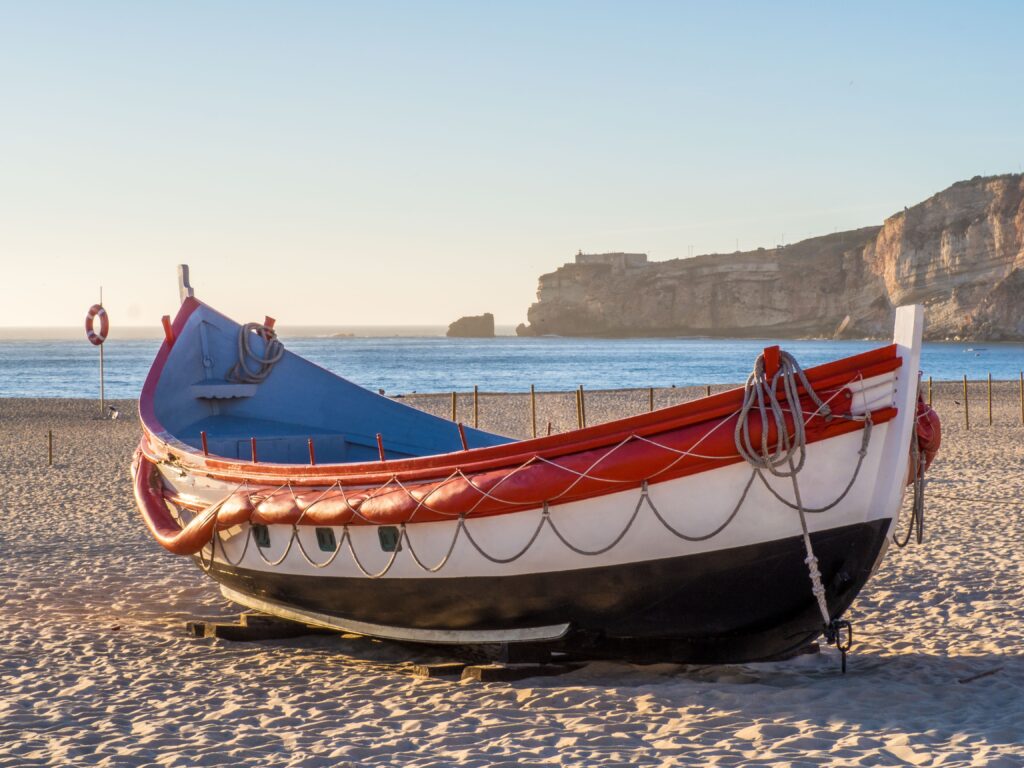 fishing boat beach nazare portugal during daytime