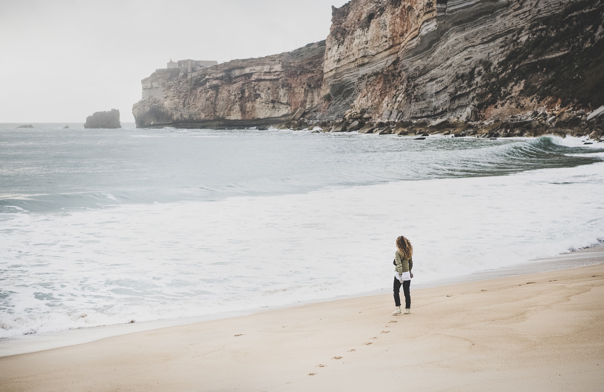 Woman tourist walking at Atlantic ocean beach in Portugal
