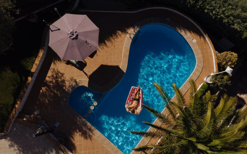 man on beach mat in swimming pool of a villa house